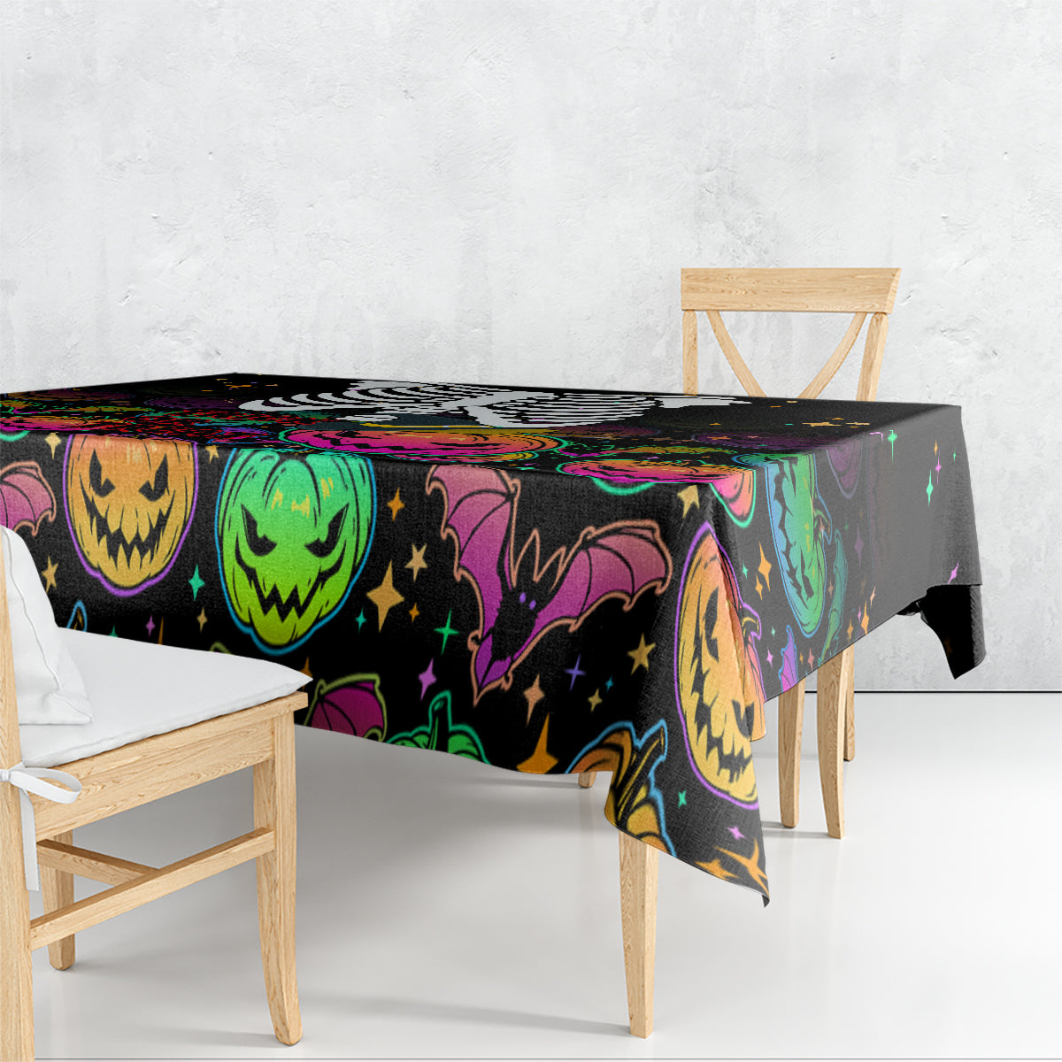 Black Halloween tablecloth draped over table with colorful jack-o’-lantern and bats