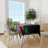 Black Halloween tablecloth with colorful pumpkin faces and bats on dining table