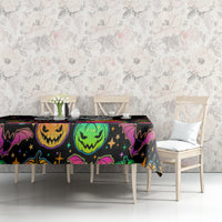 Black Halloween tablecloth with colorful pumpkin faces and bats on long dining table