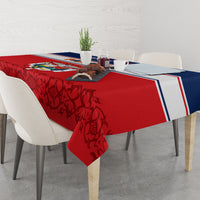 Red tablecloth with dark floral/vine pattern and blue-white border on dining table