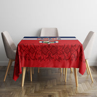 Red tablecloth with vine pattern and blue-and-white striped edge on dining table