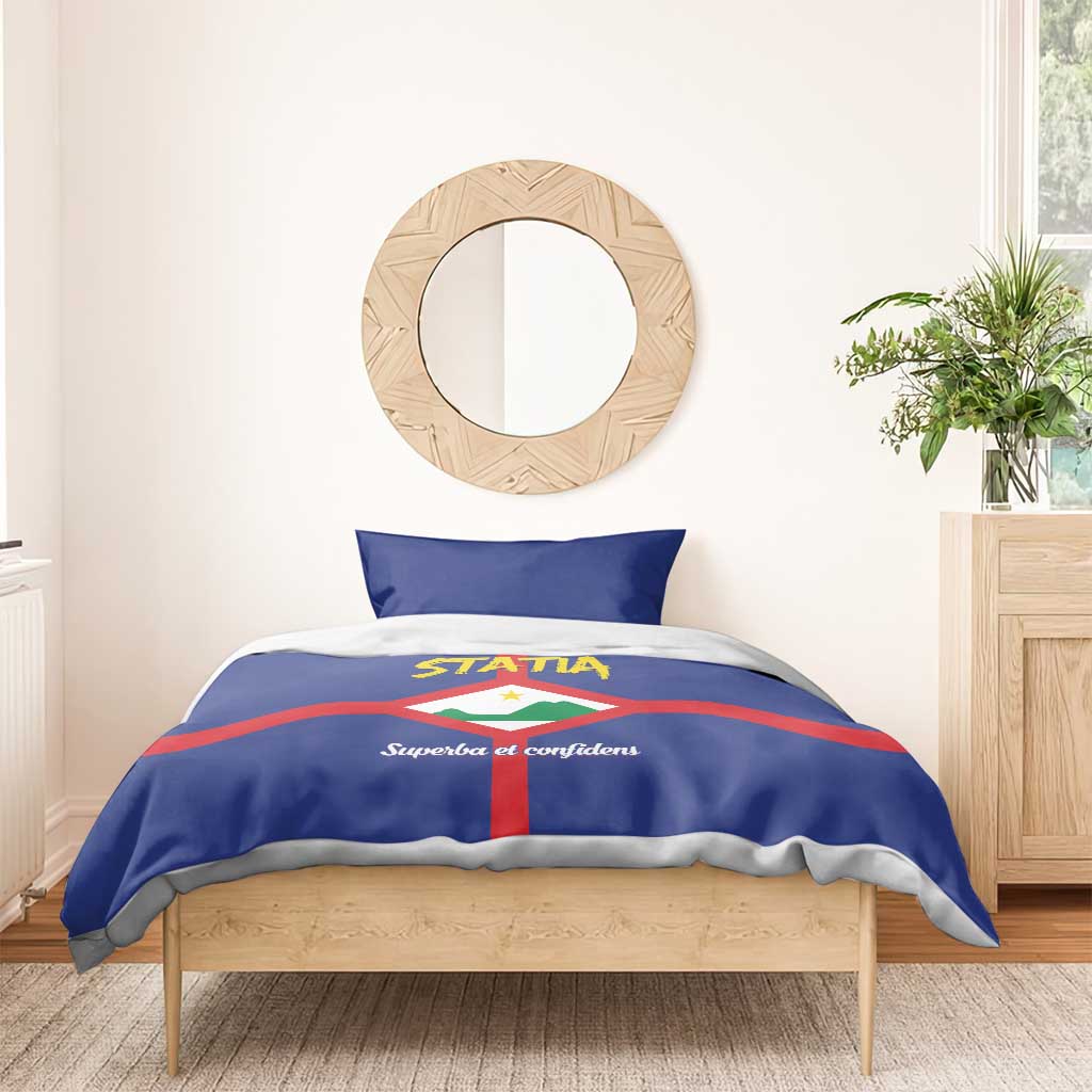 Blue duvet bedding set with STATIA logo, red cross stripes, and two pillowcases
