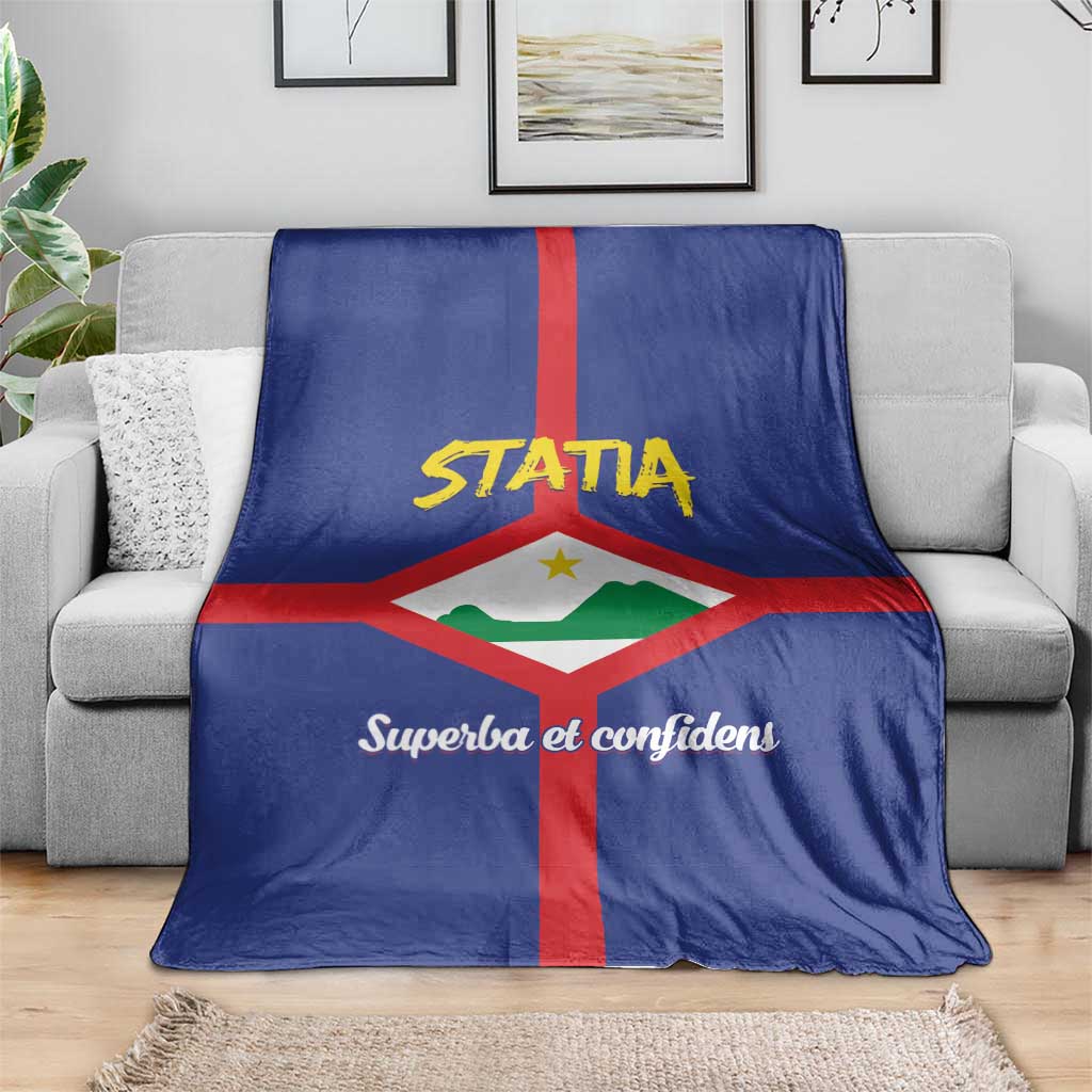 Blue coat of arms blanket draped on a sofa, showing "STATIA" and red cross