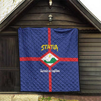 Blue quilt hanging on wall, red cross with Statia crest and yellow STATA logo, quilted