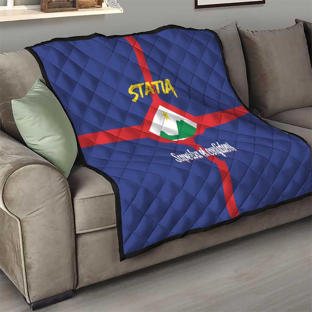 Blue quilt on sofa with red cross and Statia crest, yellow STATA logo and Superba et confidenti