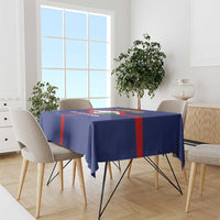 Blue tablecloth draped over dining table with red cross and crest print.