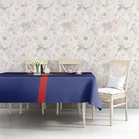 Blue tablecloth over long dining table with red cross and crest design.