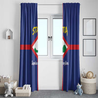 Blue window curtain panels with vertical Sint Eustatius coat of arms emblem and script text