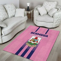Pink area rug with Bermuda logo and navy stripes on hardwood near seating