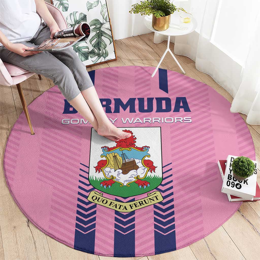 Pink round rug featuring Bermuda crest and blue striped pattern, viewed from side