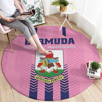Pink round rug featuring Bermuda crest and blue striped pattern, viewed from side