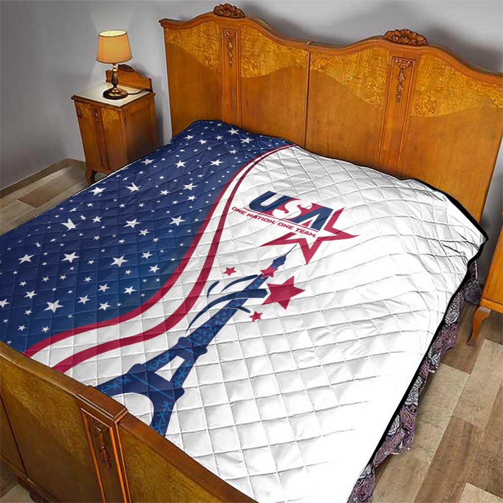 USA-themed quilt on a bed, blue stars on left, white quilted panel with Eiffel Tower logo