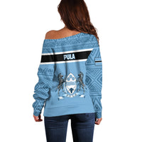 Women’s blue off-shoulder sweater back view with geometric pattern and Botswana stripe