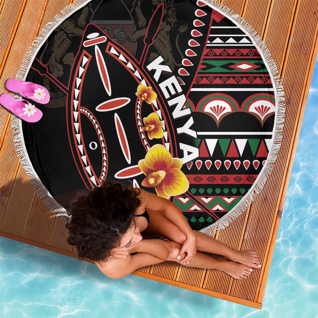 Black round beach blanket with colorful shield artwork, fringed border, and floral details