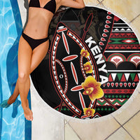 Black round beach blanket with colorful shield graphic and white fringed border