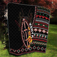 Black quilt blanket with colorful geometric borders and central tribal shield illustration.