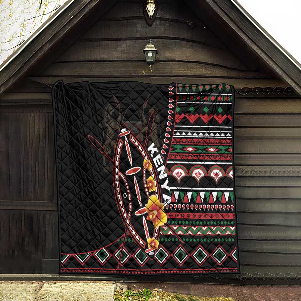 Black quilt hanging outdoors with colorful tribal stripes, diamonds, and shield motif.