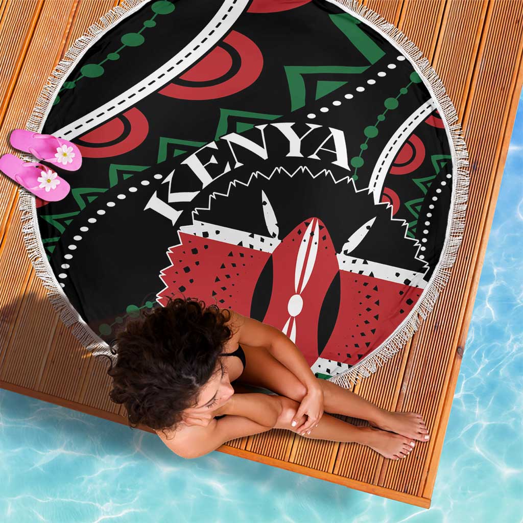 Round beach blanket with fringe on black base; colorful Kenya graphic center