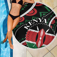 Round beach blanket draped at poolside; black Kenya design with white fringe
