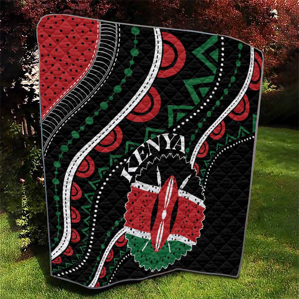 Black quilt with Kenya word, red star flower, green arrow shapes, and white dotted trim