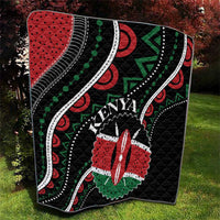 Black quilt with Kenya word, red star flower, green arrow shapes, and white dotted trim