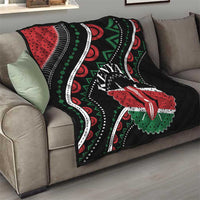 Black quilt on sofa with red-and-green star flower, Kenya text, and white curved stitch lines