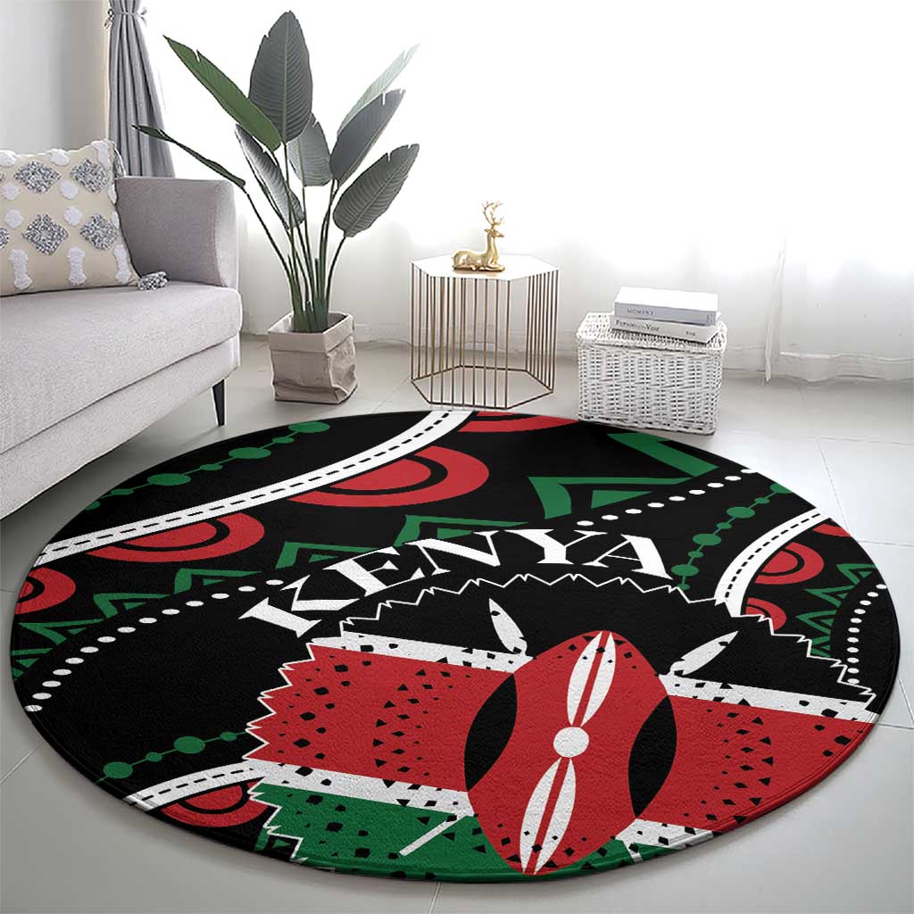 Round black area rug with bold red and green patterns and white detailing
