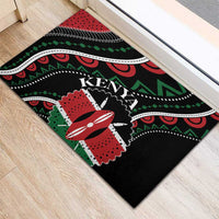 Black rubber doormat featuring Kenya wordmark and red flower-like emblem with green accents.