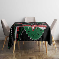 Black tablecloth with bold green and red African pattern, draped over table