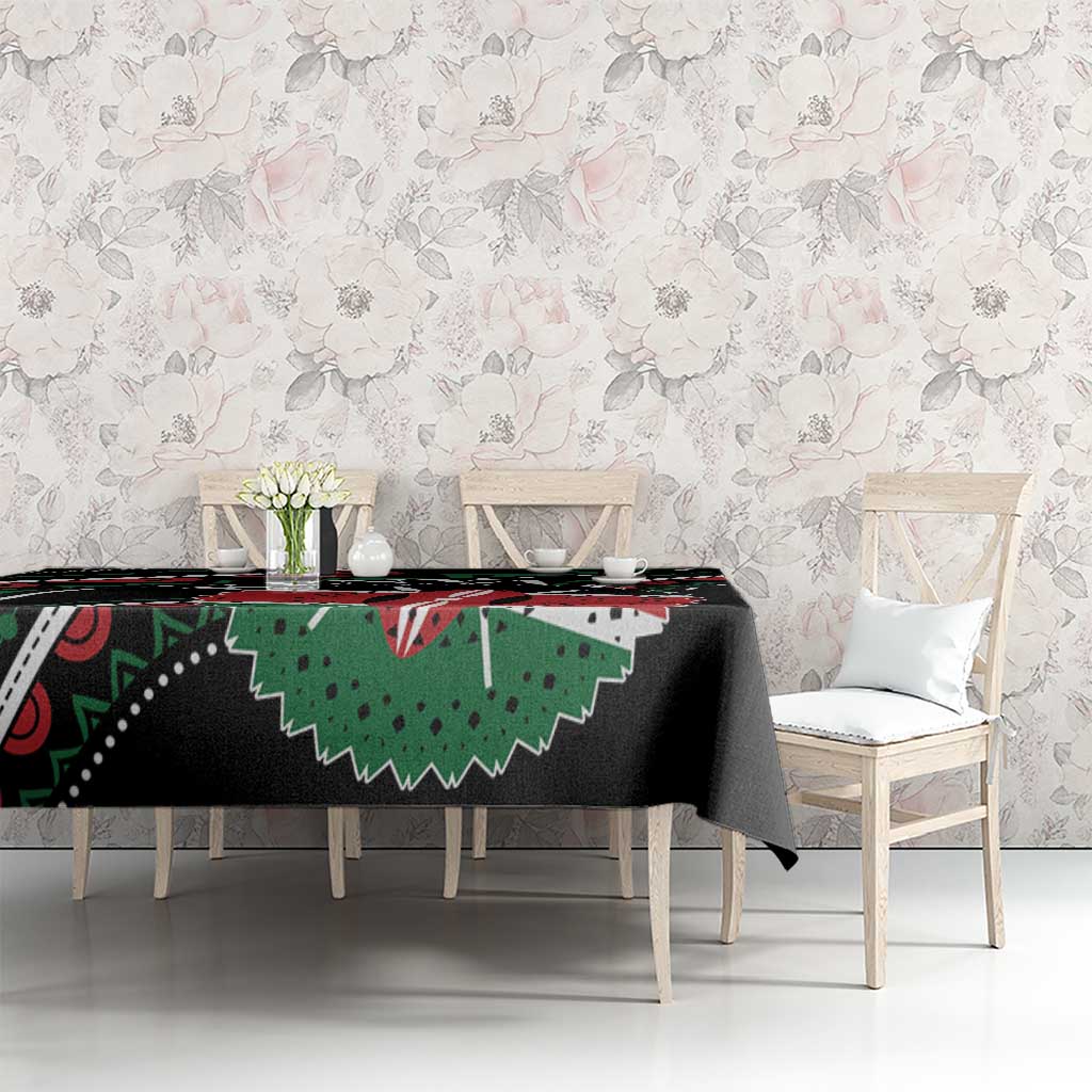 Black tablecloth with green and red African pattern, draped over table