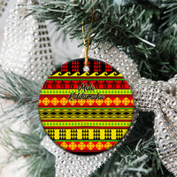 Ceramic circle Christmas ornament with Hawaiian quilt pattern, red/yellow/green, hanging on tree