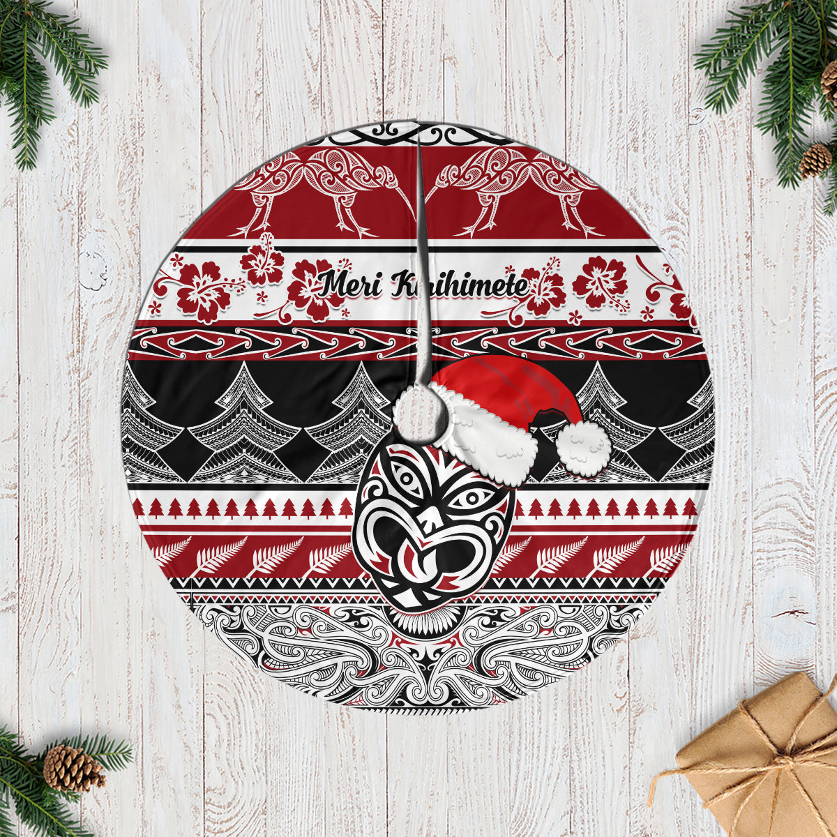 Red Christmas tree skirt with Maori-style pattern and koru face; round design