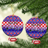 Blue circular ceramic Christmas ornament with Croatian embroidery pattern and gold loop.
