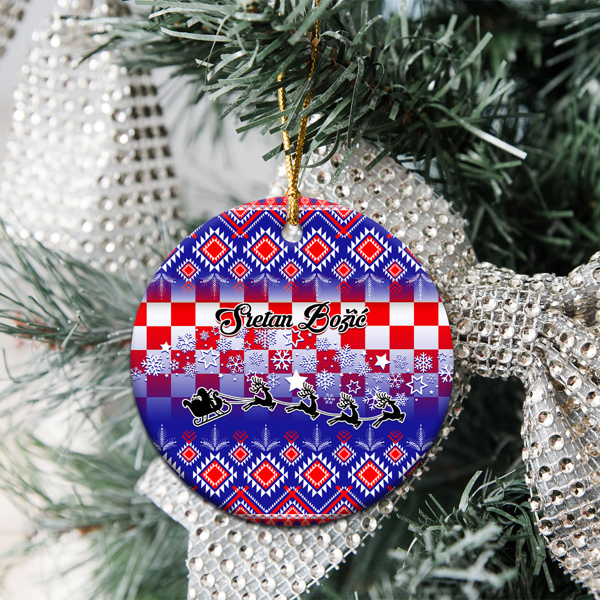 Blue circular ceramic ornament on a tree branch, Croatian embroidery pattern, gold hanger.