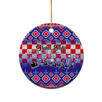 Blue circular ceramic Christmas ornament with Croatian embroidery pattern and gold string.