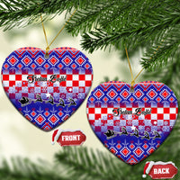Two blue ceramic heart ornaments with Croatian embroidery pattern, gold loops visible.