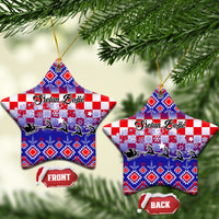 Two blue ceramic star ornaments with Croatian embroidery pattern and gold loops.