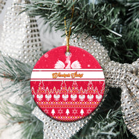 Red round ceramic Christmas ornament close-up with white eagle motif, striped band, gold loop