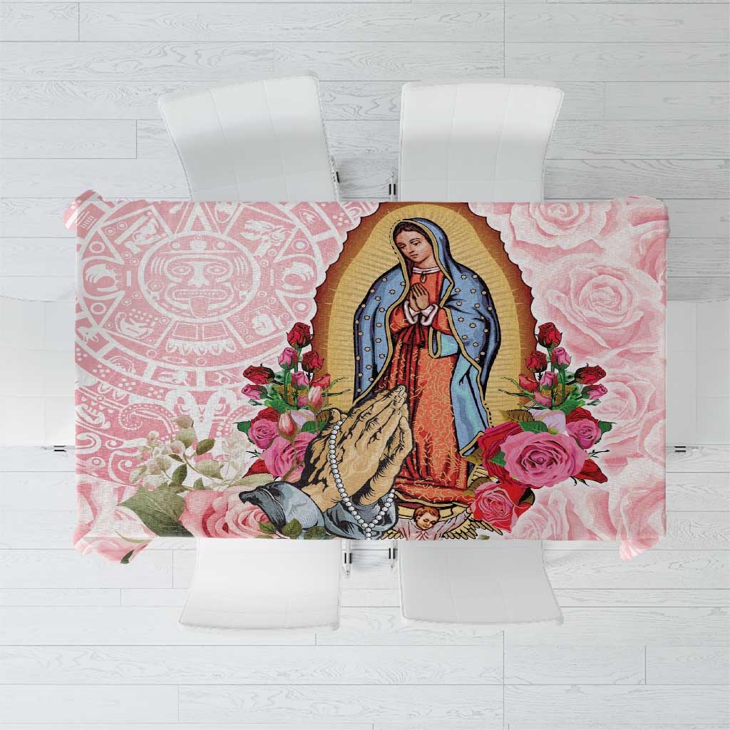 Pink tablecloth with Virgin of Guadalupe portrait, roses, and decorative border patterns.