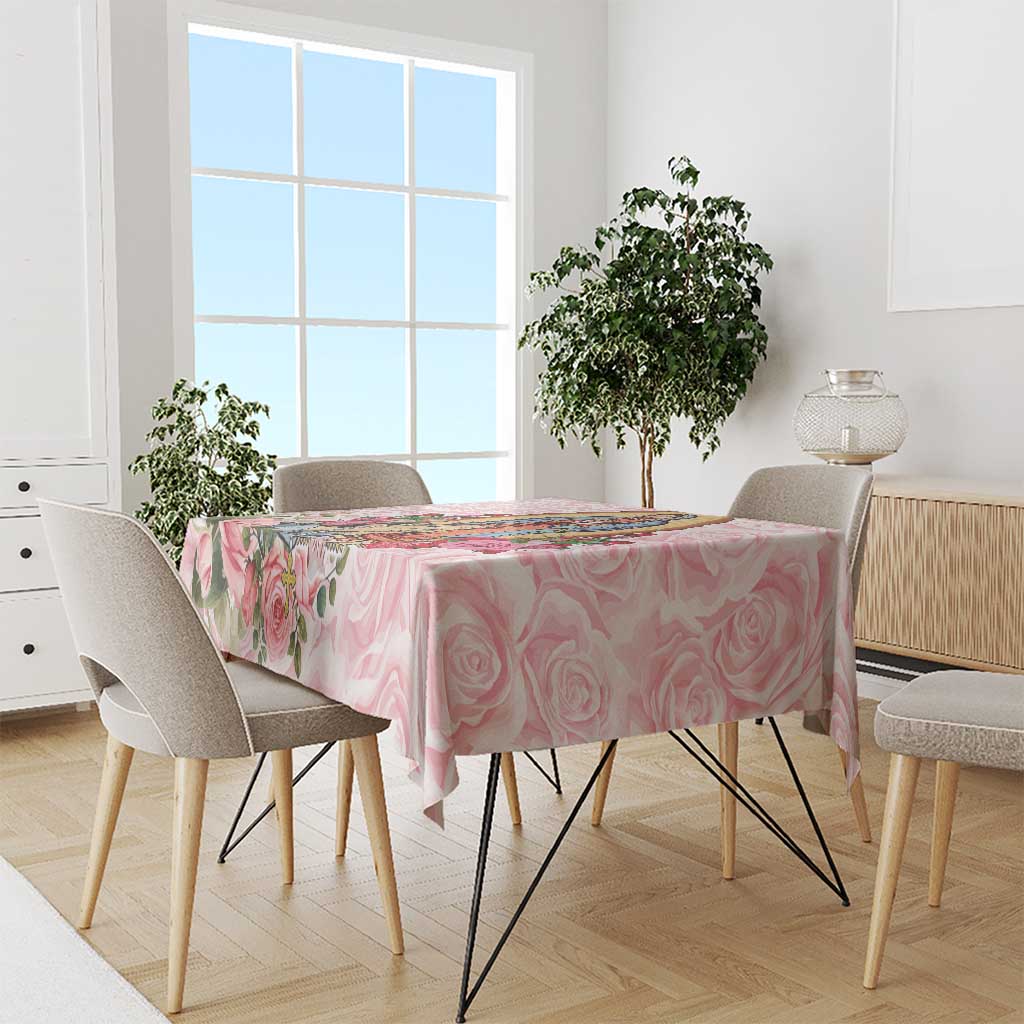 Pink rose-pattern tablecloth with scalloped floral print across the tabletop edge.