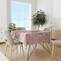 Pink rose-pattern tablecloth with scalloped floral print across the tabletop edge.