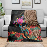 Black blanket draped over sofa with colorful floral skull motifs and Aztec-style medallion