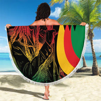 Round beach blanket held outdoors showing reggae lion portrait and flag colors with fringe