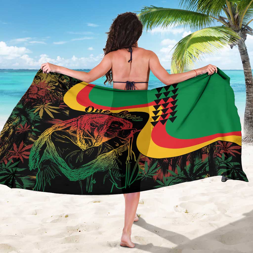 Green reggae sarong held wide, featuring One Love text and portrait with red-yellow bands