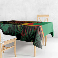 Green tablecloth with colorful reggae graphic design, draped over table edge