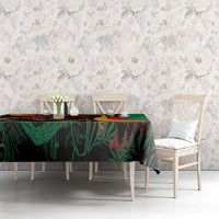 Green tablecloth with multicolor reggae graphic print covering the dining table