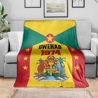 Grenada flag style fleece blanket with Gwenad 1974 crest and stars, laid over gray couch