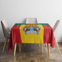 Red and yellow Grenada coat of arms tablecloth centered on a dining table