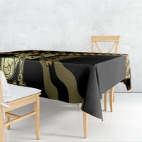 Black tablecloth with gold geometric pattern and green ornamental design, draped on table