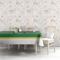 Green and yellow striped rugby tablecloth on dining table in floral room setting